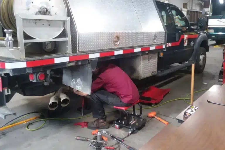 image of truck mechanic under medium duty truck vehicle
