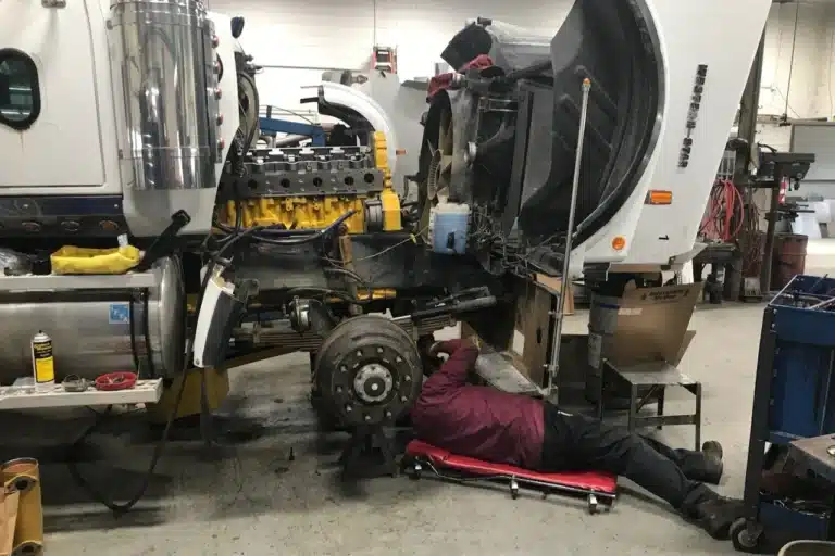 image of mechanic under truck cab